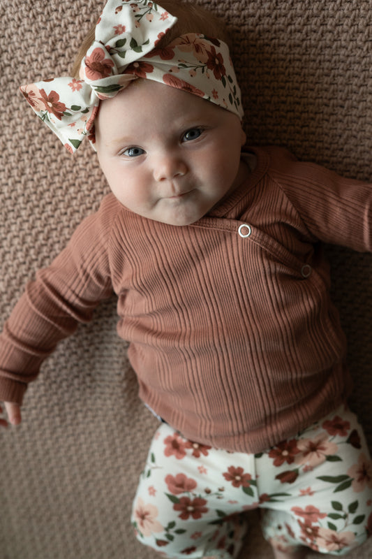 Baby draagt overslagshirtje klei roze van ribstof