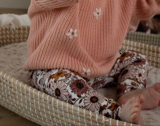 Baby draagt broekje met madeliefjesprint